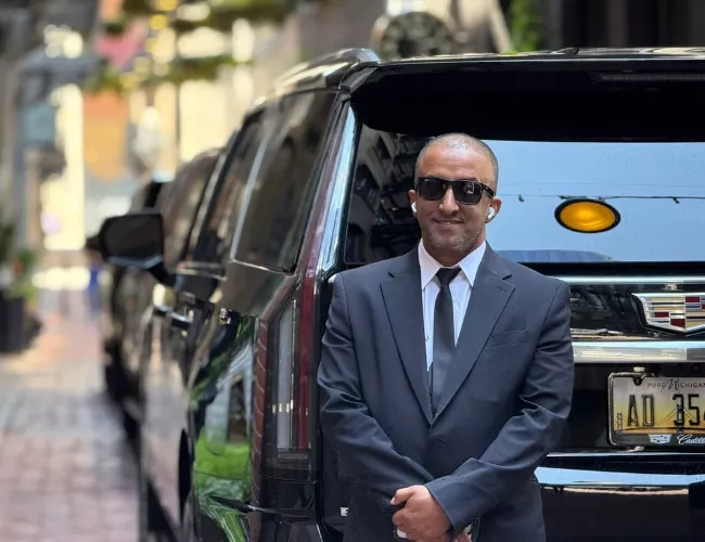 chauffeur standing with a suv